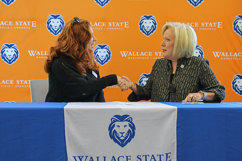 Christina Hernandez of Slim Chickens shakes hands with Wallace State President Dr. Vicki Karolewics after signing the Powerful Partnerships Agreement.